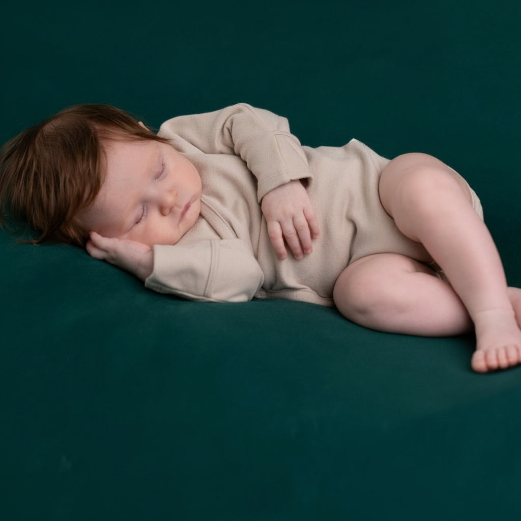 Baby sleeping wearing organic  beige romper