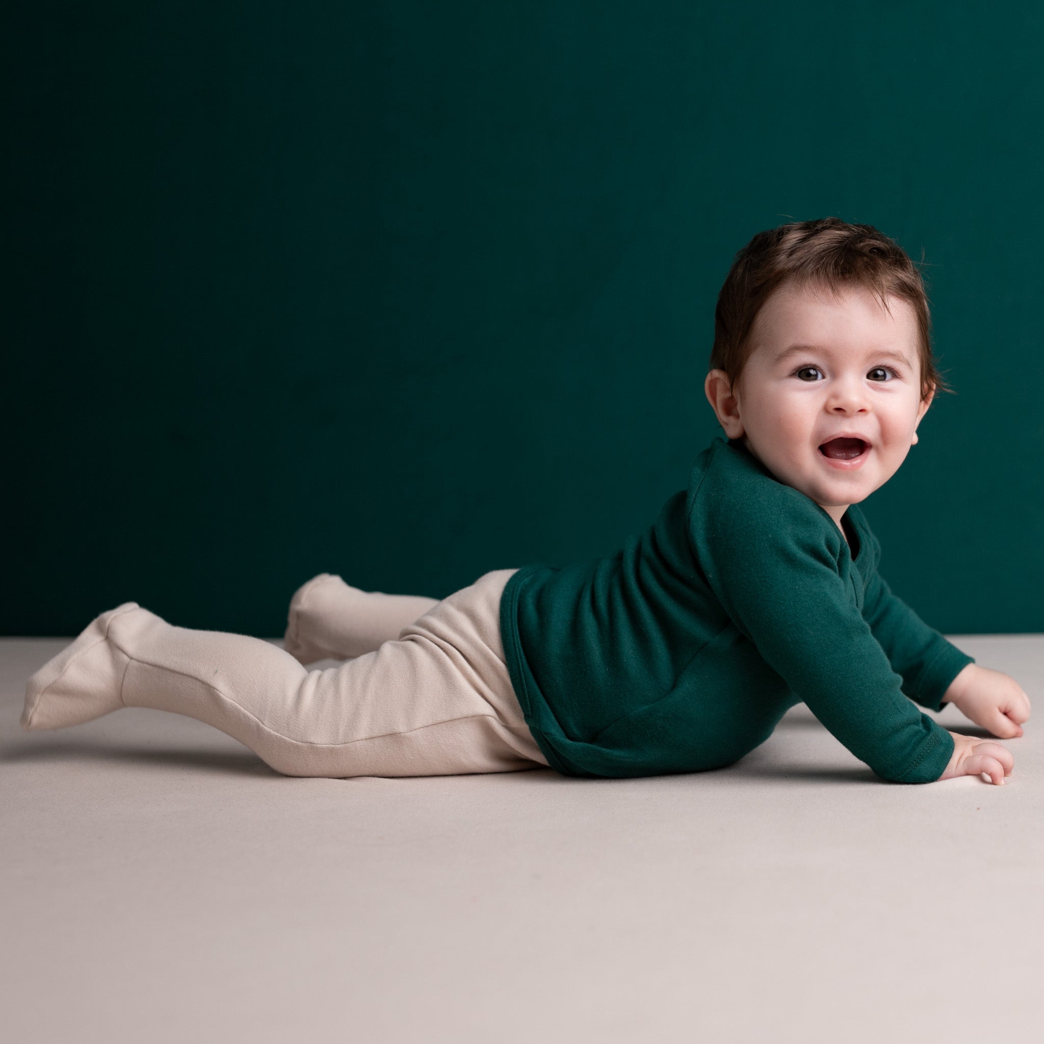 A smiling baby wearing full-bottomed organic cotton trousers